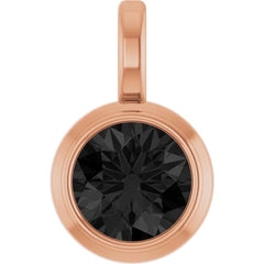 A round rose gold pendant featuring a faceted black gemstone in a bezel setting, complete with a top loop, shown on a solid white background.