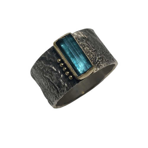 blue tourmaline crystal in gold on erosion band